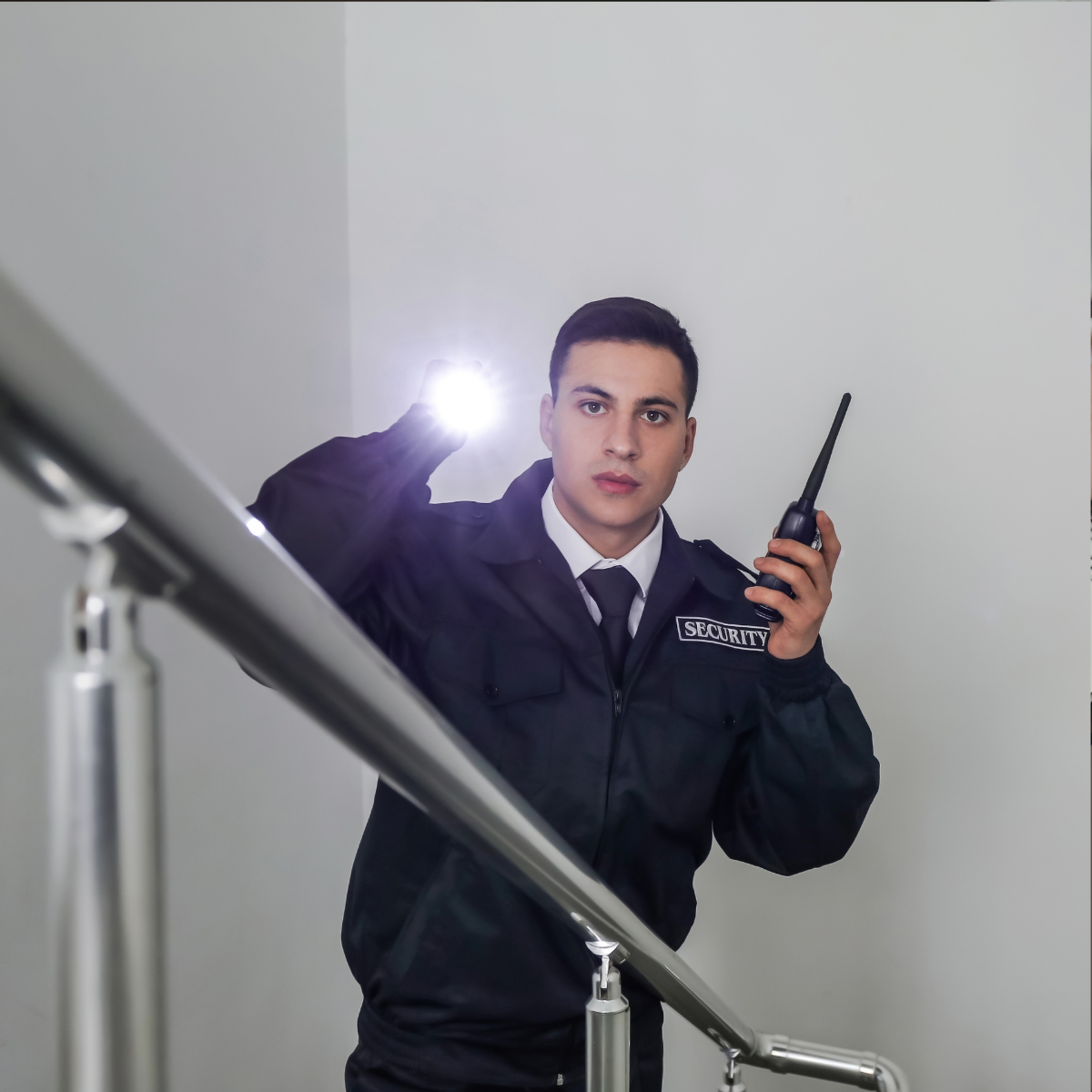 Agent de sécurité privé effectuant sa ronde, lampe torche en main. Le premier contact visuel compte pour donner confiance au recruteur. Agent de sécurité privé effectuant sa ronde, lampe torche en main.