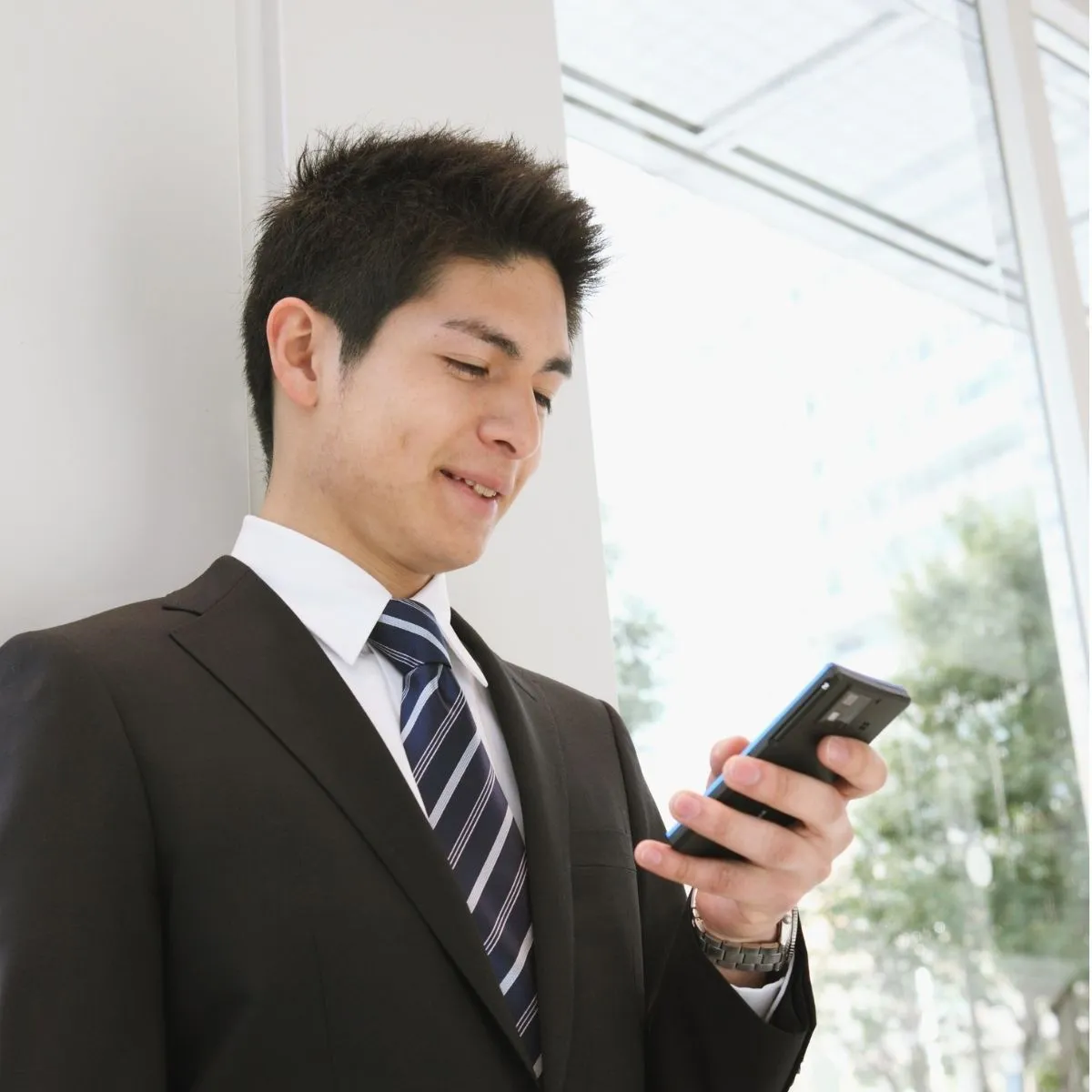 Agent de sécurité consultant l'application d'une plateforme de recrutement spécialisée en sécurité privée. Agent de sécurité consultant son smartphone.