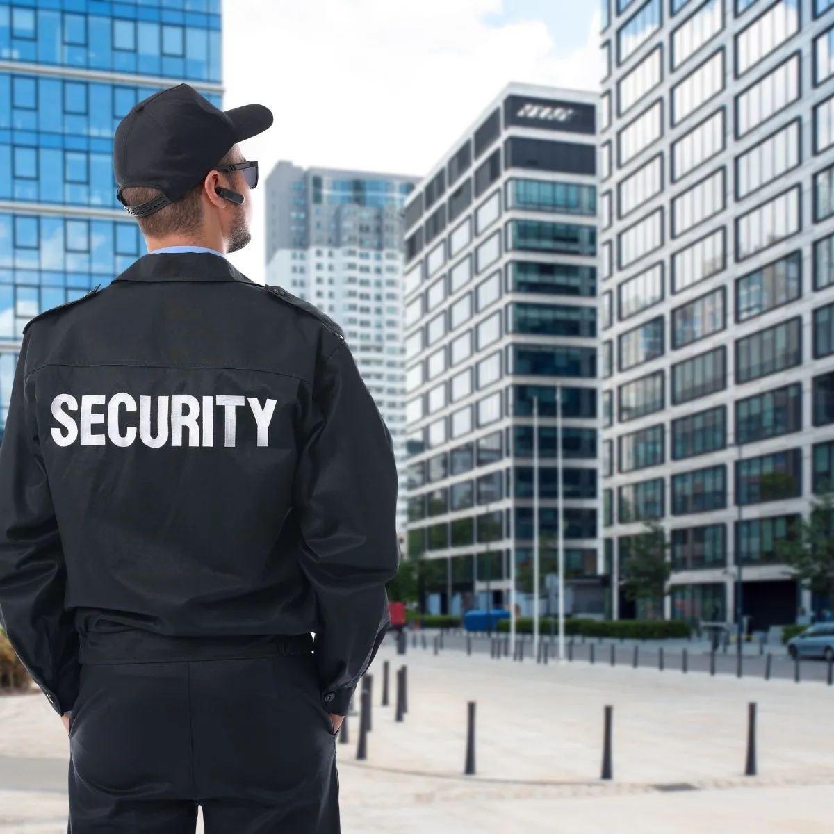 Agent de sécurité en uniforme debout devant un bâtiment, symbolisant le rôle de chef d’équipe en coordination d’une équipe de sécurité. Agent de sécurité en uniforme debout devant un bâtiment.