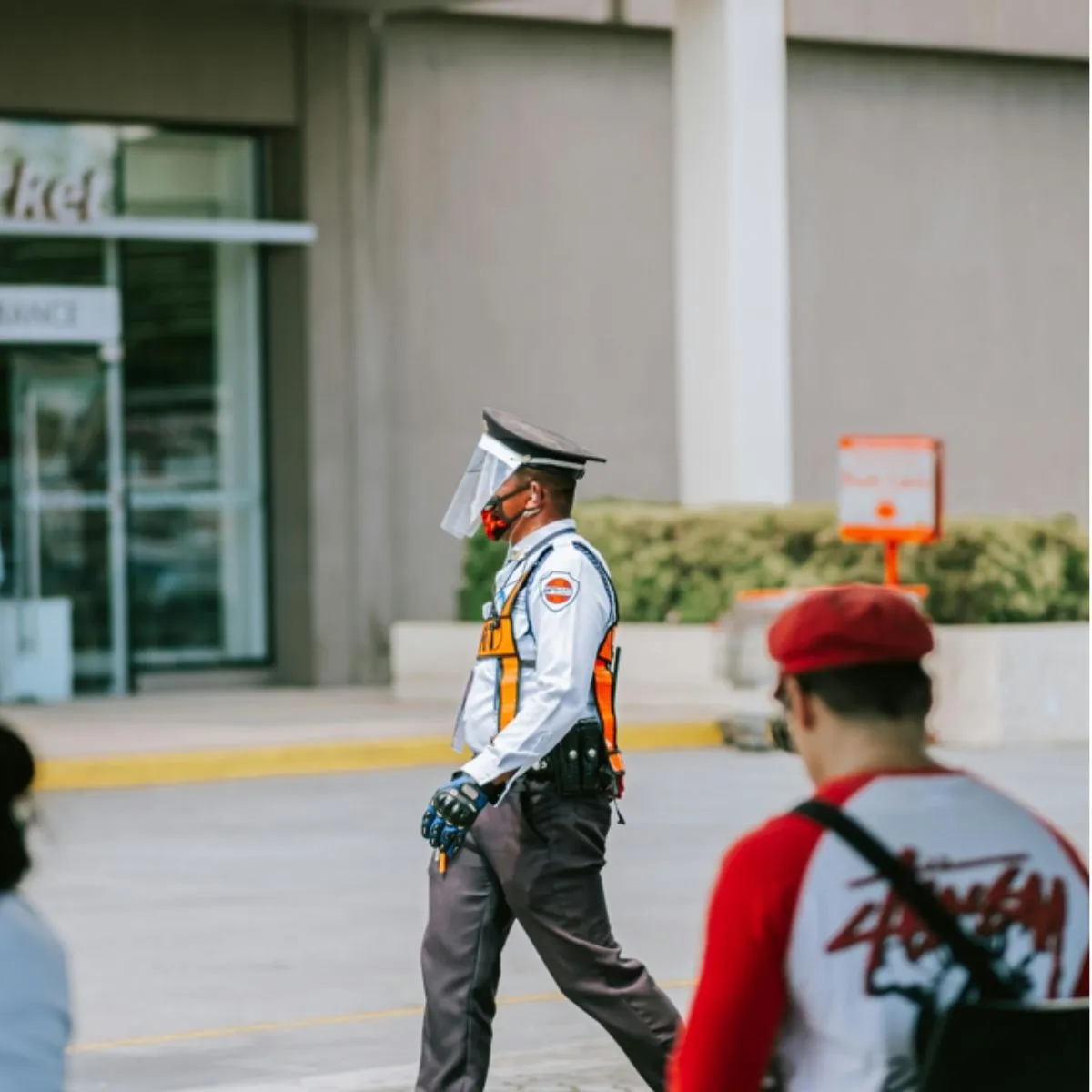 Agent de sécurité privé en uniforme marchant à l’extérieur – un métier exigeant où la fidélisation est essentielle. Agent de sécurité privé en uniforme marchant à l’extérieur.