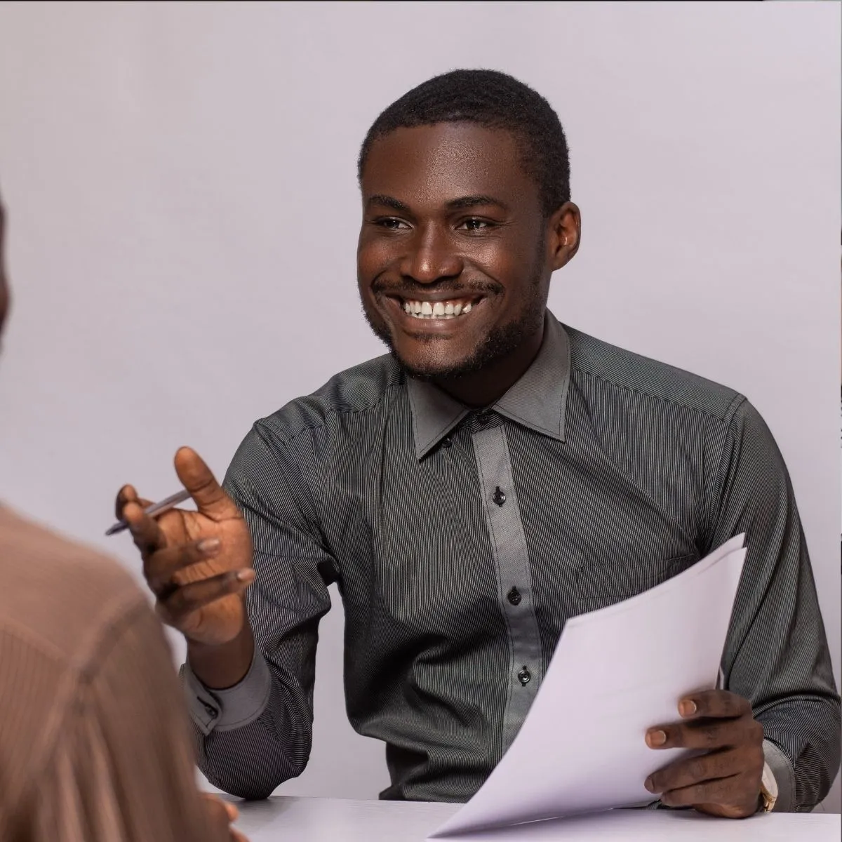 Un recruteur en entretien avec une candidate, tenant un dossier. Un recruteur en entretien avec une candidate, tenant un dossier.