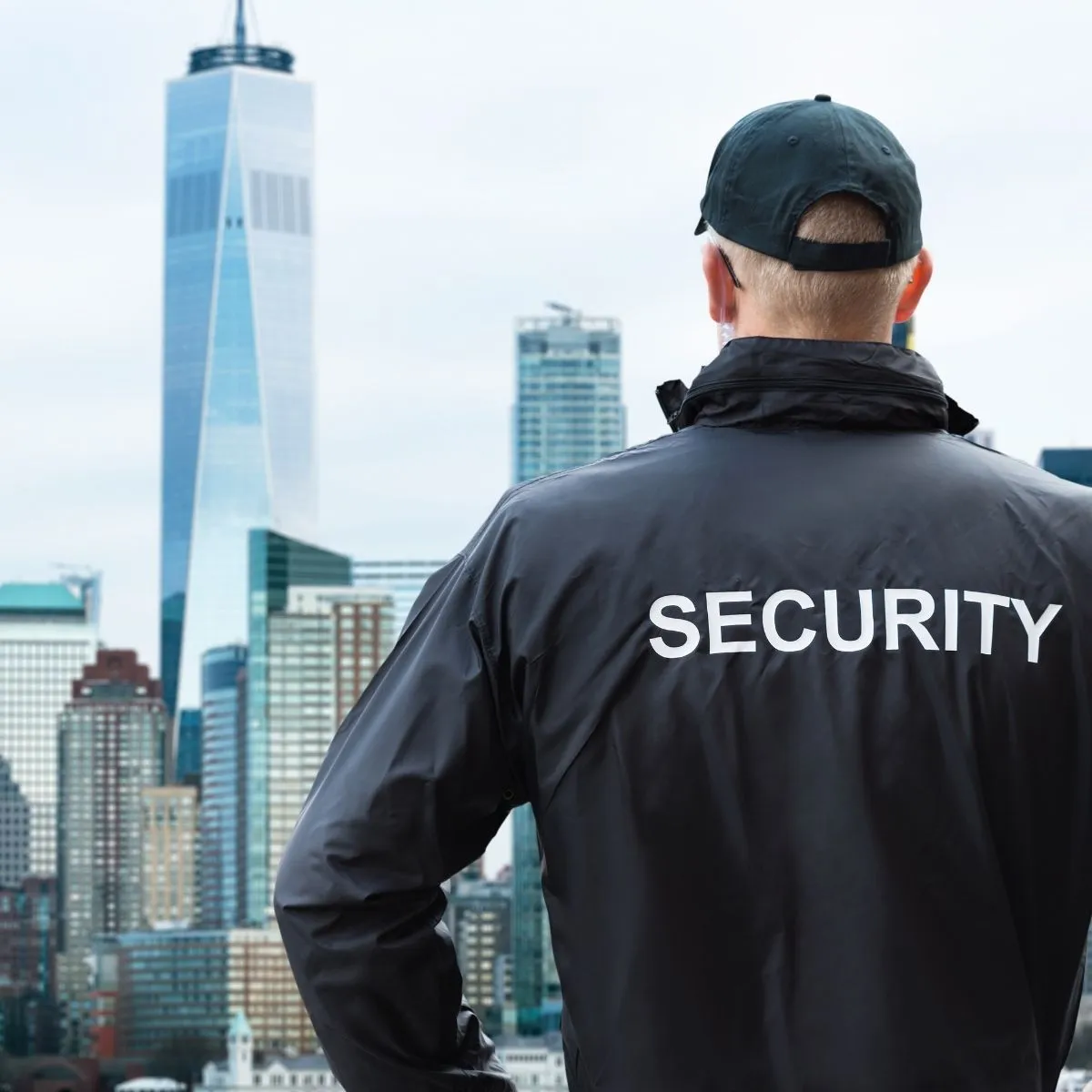 Un agent de sécurité en uniforme se tient à l’entrée d’un immeuble, symbole des missions variées du métier. Un agent de sécurité en uniforme se tient à l’entrée d’un immeuble.